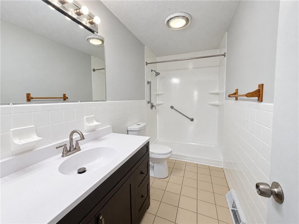 Walk-in shower, tiled shower and double vanity at 1400 NW 65th Terrace, Kansas City, MO 64118