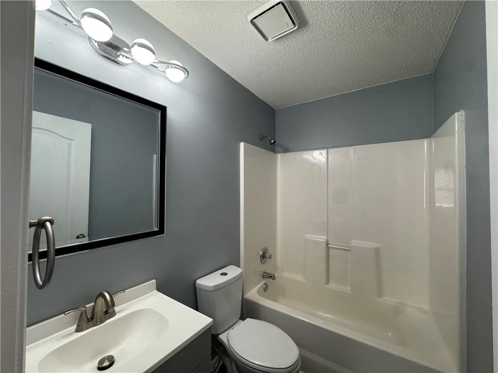 Tiled shower, white vanity and renovated bathrooms at 2104 Garfield Avenue, Kansas City, MO 64127