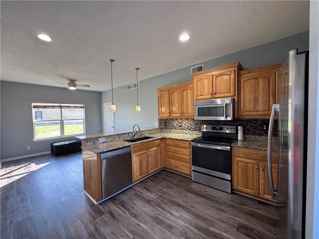 Open floor plan, kitchen island and electric range at 2104 Garfield Avenue, Kansas City, MO 64127