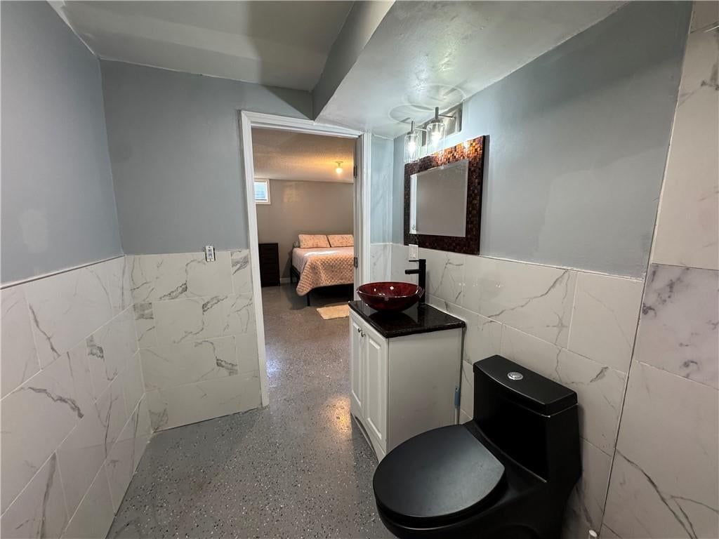 Private toilet room, double vanity and frameless glass shower at 2104 Garfield Avenue, Kansas City, MO 64127