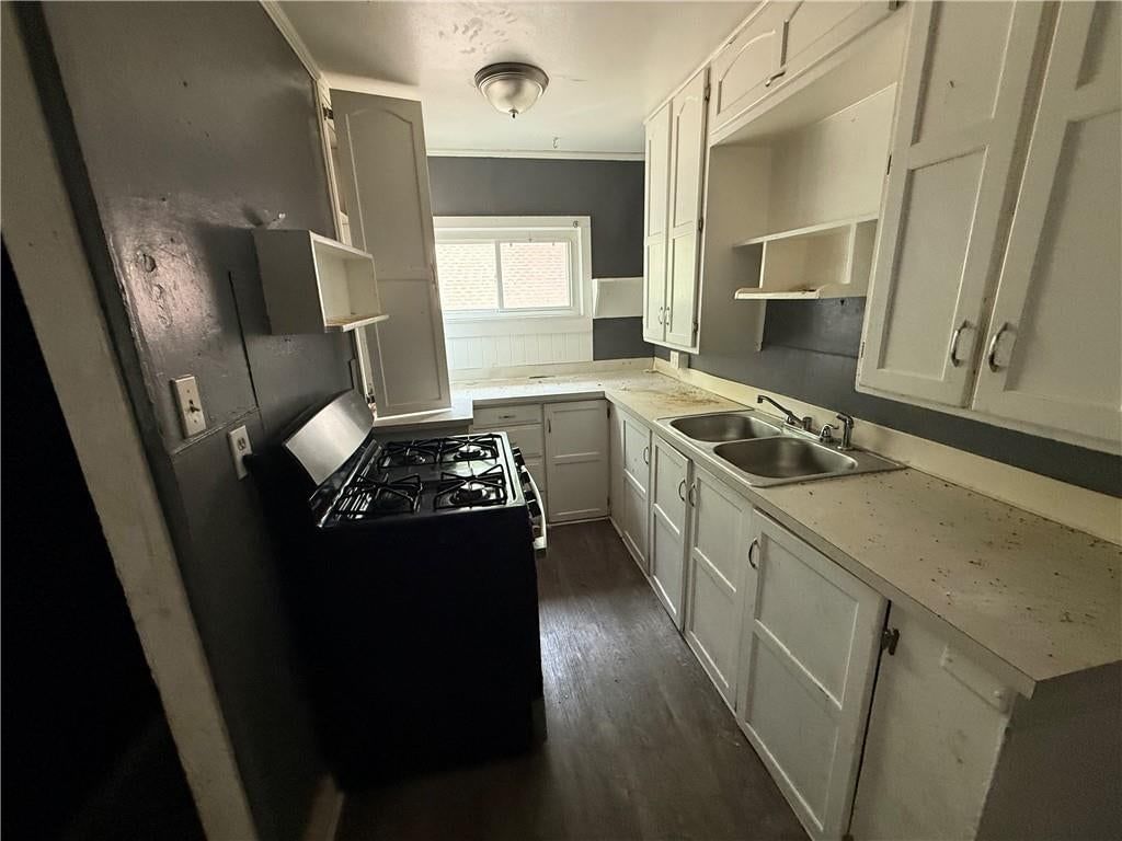 White kitchen, gas range and black appliances at 2000 NE 37th Terrace, Kansas City, MO 64116