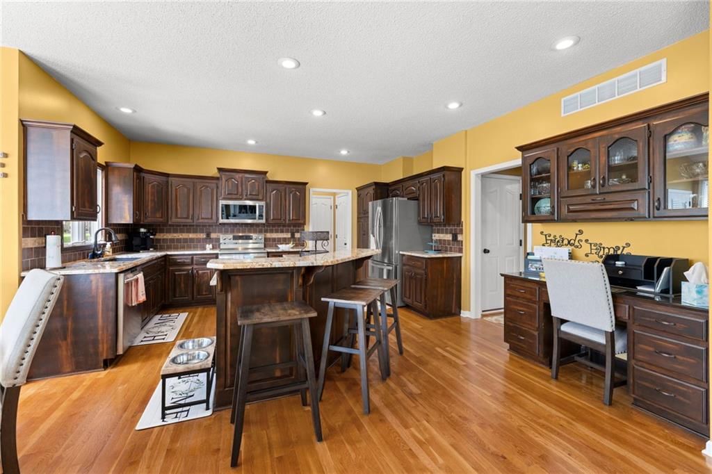 Kitchen island, granite counters and stainless steel appliances at 22007 52nd Street, Shawnee, KS 66226