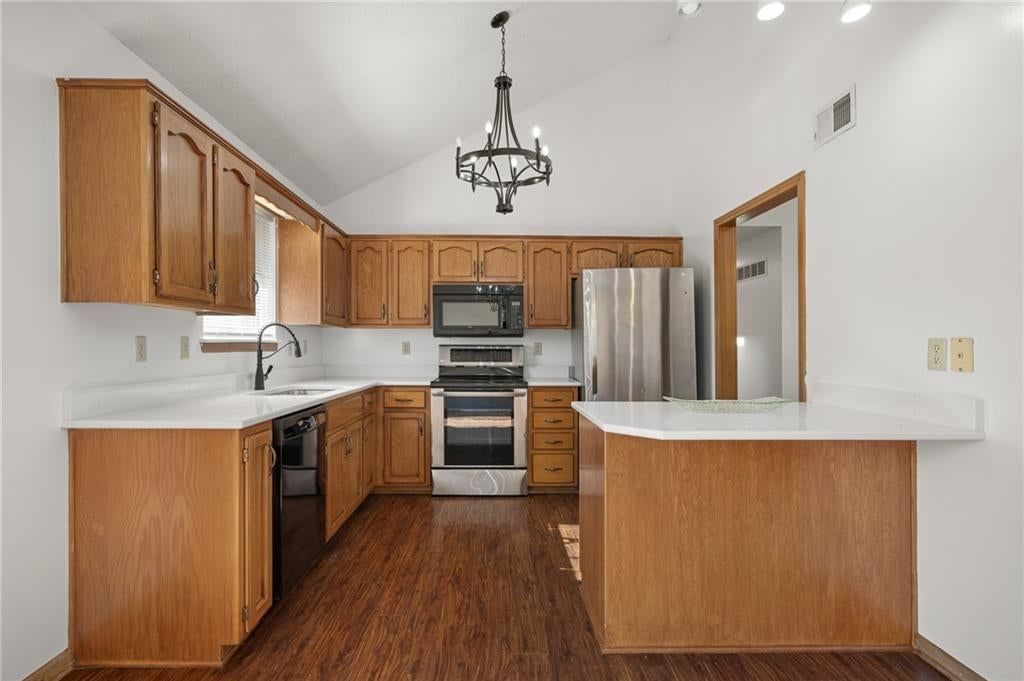 Kitchen island, stainless steel appliances and white countertops at 2513 SE WINCHESTER Drive, Lee's Summit, MO 64063