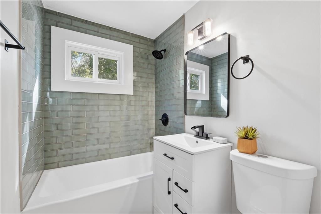 Tiled shower, white vanity and renovated bathrooms at 8503 Crystal Avenue, Kansas City, MO 66209