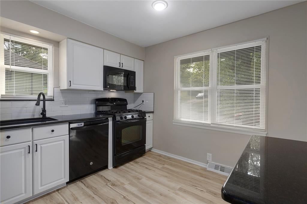 White kitchen, gas range and shaker cabinets at 5708 NE 50th Street, Kansas City, MO 64119