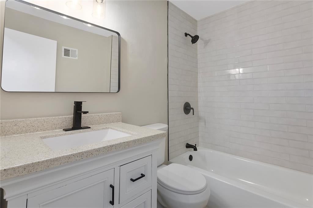 Tiled shower, white vanity and tub and shower combo at 5708 NE 50th Street, Kansas City, MO 64119