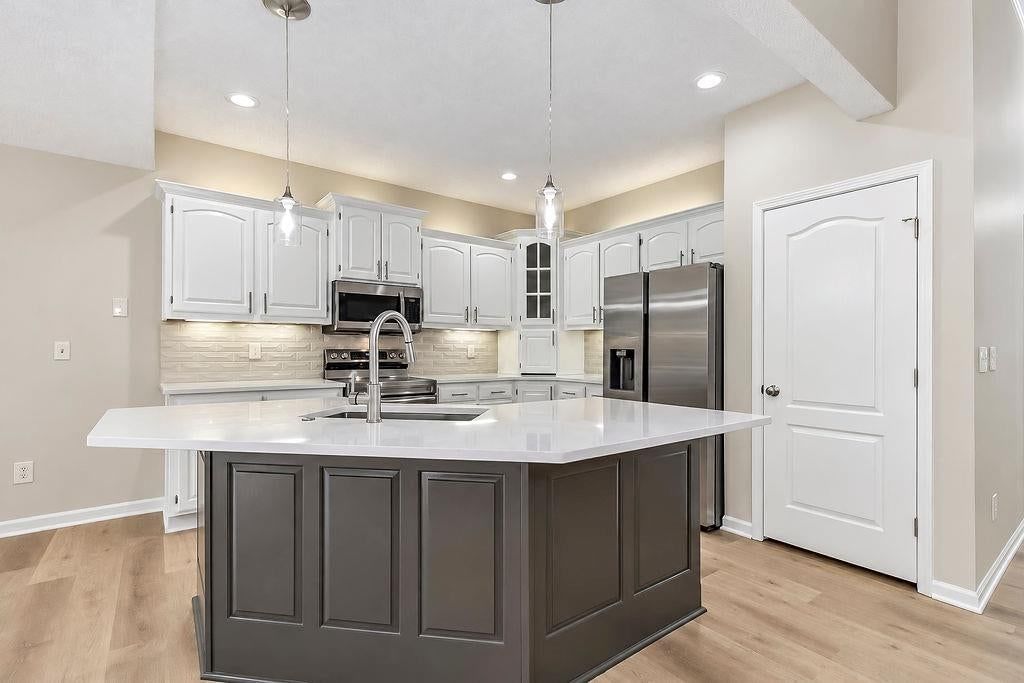 Kitchen island, white kitchen and quartz counters at 9605 NE 100th Street, Kansas City, MO 64157