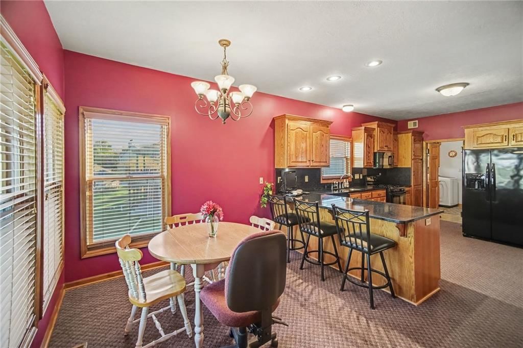 Kitchen island, breakfast nook and black appliances at 12554 Prestwick Lane, Kansas City, KS 66109