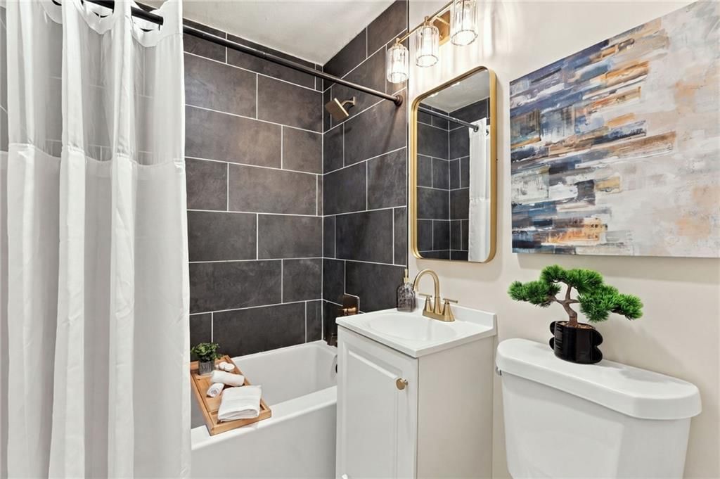 Tiled shower, white vanity and renovated bathrooms at 7907 Reinhardt Lane, Prairie Village, KS 66204