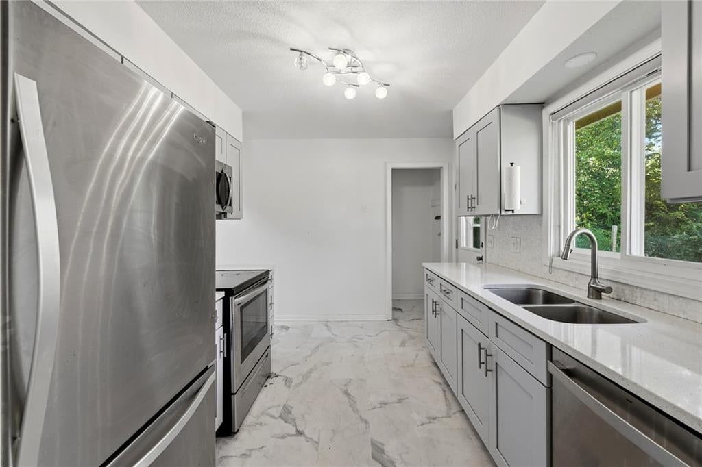 Gray kitchen cabinets, shaker cabinets and stainless steel appliances at 2216 NE 39th Terrace, Kansas City, MO 64116