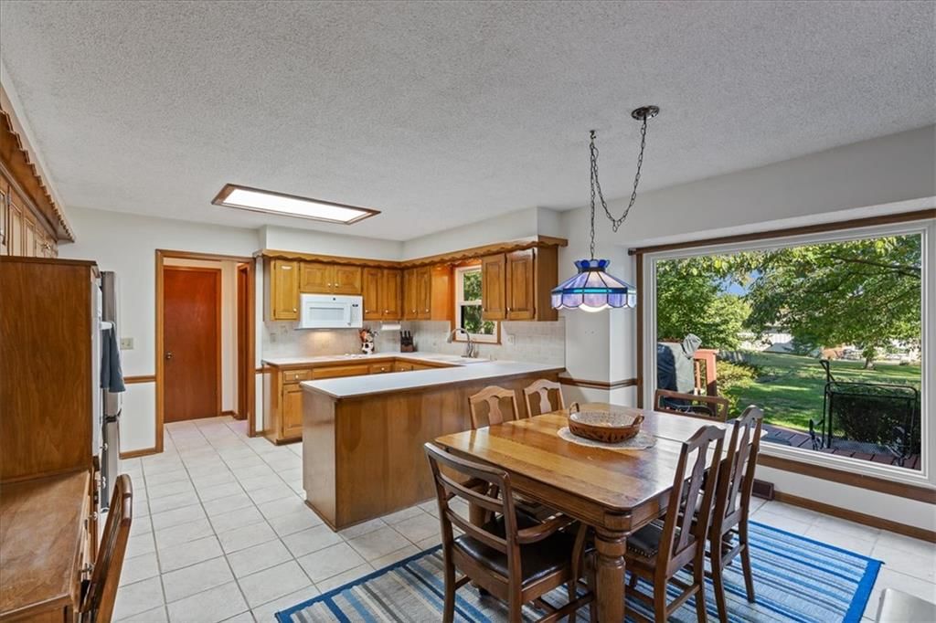 Kitchen open to the living area, kitchen island and tile floors at 204 NW Cypress Street, Lee's Summit, MO 64064
