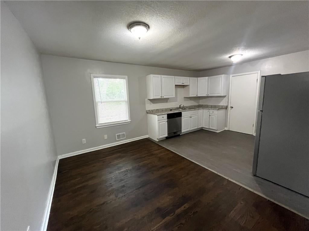 Open floor plan, white kitchen and breakfast nook at 7416 Montgall Avenue, Kansas City, MO 64132