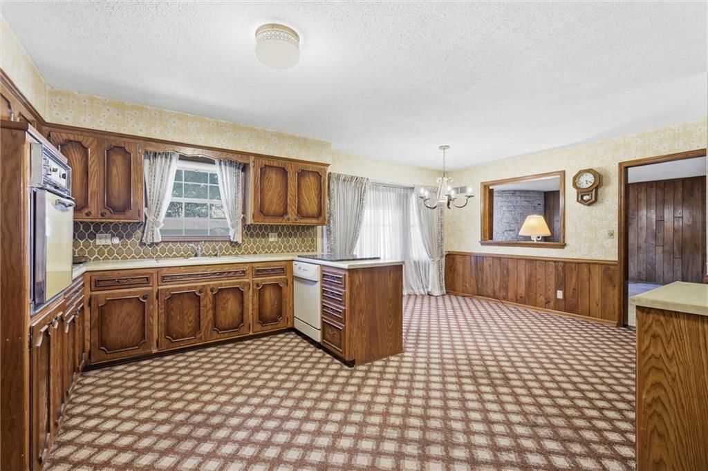 Kitchen island, wood kitchen cabinets and white appliances at 9209 W 47th Street, Merriam, KS 66203