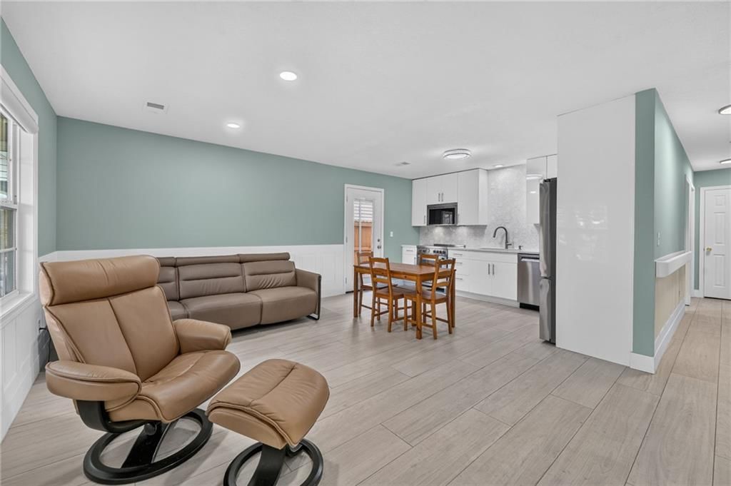 Open floor plan, main-floor primary bedroom and white kitchen at 123 E Madison Street, Gardner, KS 66030