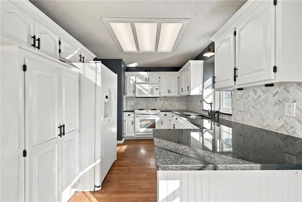 White kitchen, white appliances and kitchen backsplash at 18107 E 51st Street Court, Independence, MO 64055