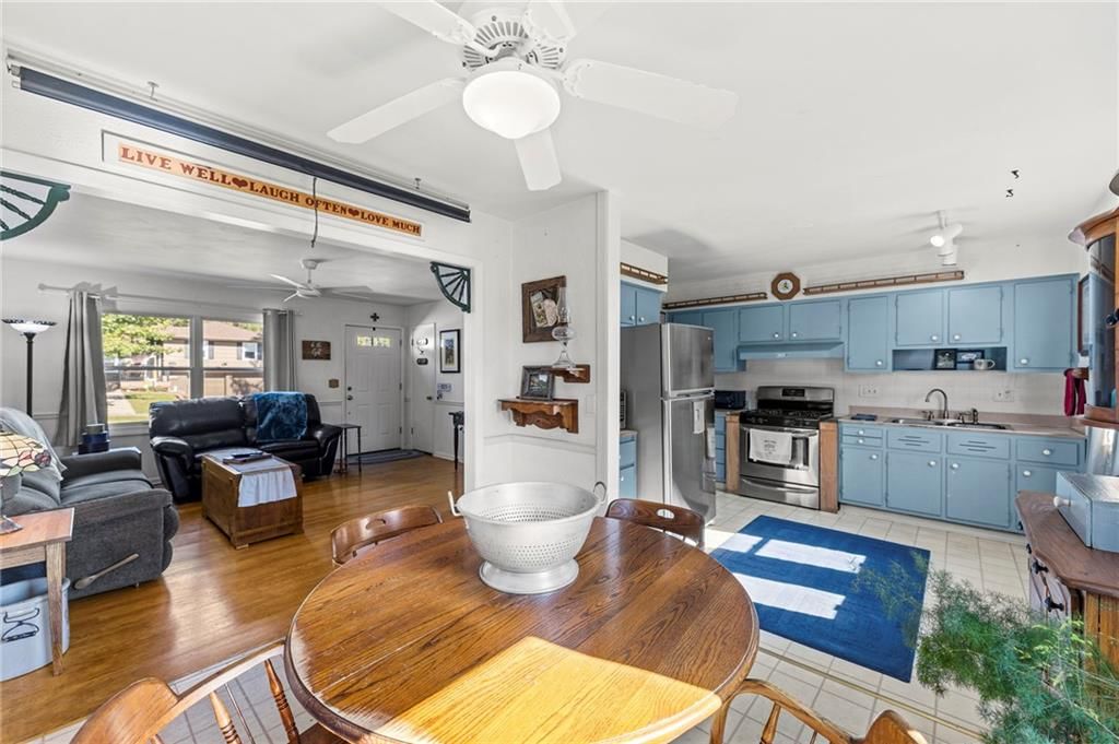 Kitchen island, blue kitchen cabinets and stainless steel appliances at 8809 W 94th Street, Overland Park, KS 66212