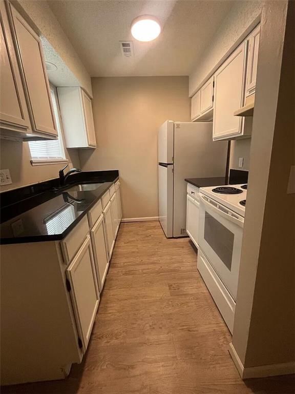 White kitchen, quartz counters and shaker cabinets at 4316 Jarboe Street, Kansas City, MO 64111
