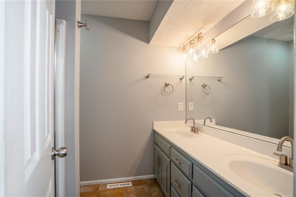 Tiled shower, double vanity and gray vanity at 1122 E Frontier Drive, Olathe, KS 66062