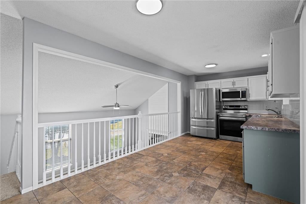 Kitchen island, quartz counters and shaker cabinets at 1122 E Frontier Drive, Olathe, KS 66062
