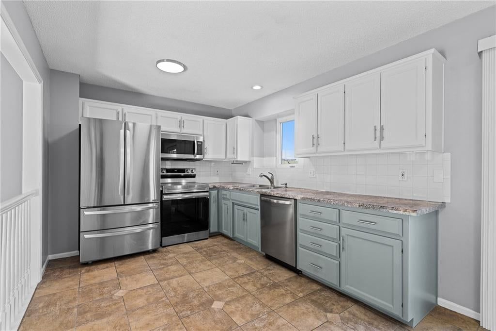Two-tone kitchen cabinets, double oven and updated kitchen at 1122 E Frontier Drive, Olathe, KS 66062