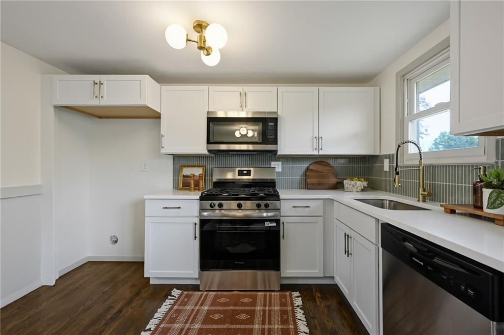 White kitchen, quartz counters and gas range at 6813 N Tracy Avenue, Gladstone, MO 64118