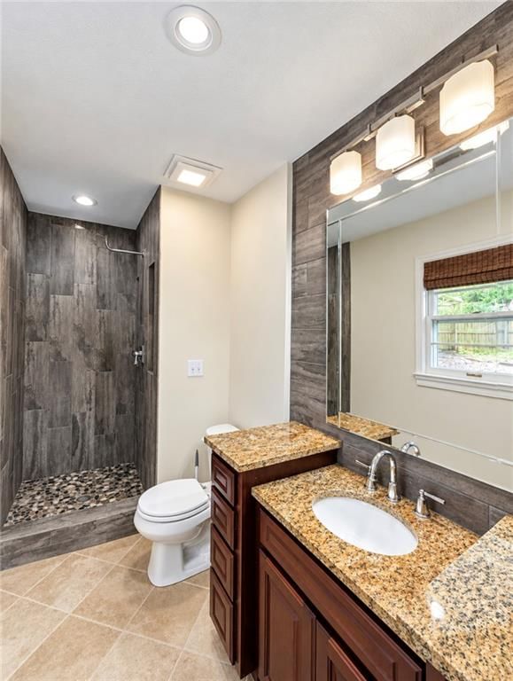 Walk-in shower, tiled shower and wood vanity at 15109 E 40th Street S, Independence, MO 64055
