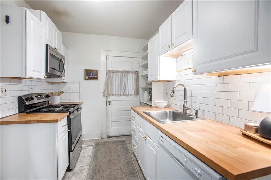 Butcher block countertops, electric range and kitchen backsplash at 4346 Campbell Street, Kansas City, MO 64110