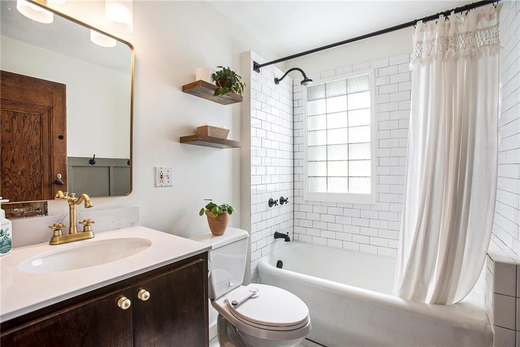 Tiled shower, black vanity and renovated bathrooms at 4346 Campbell Street, Kansas City, MO 64110