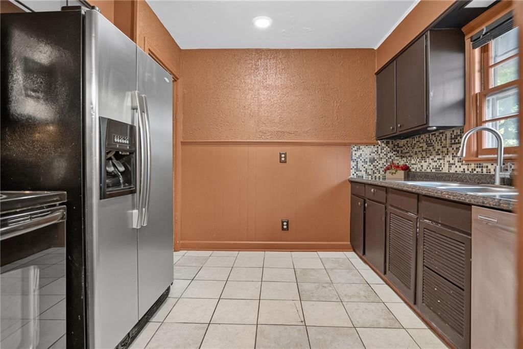 Granite counters, stainless steel appliances and kitchen backsplash at 611 W 85th Street, Kansas City, MO 64114