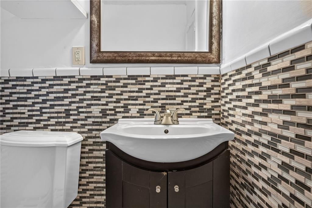 Tiled shower, double vanity and black vanity at 611 W 85th Street, Kansas City, MO 64114
