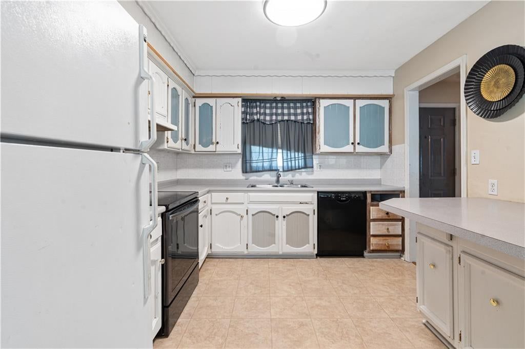 White kitchen, white appliances and kitchen backsplash at 16925 E 4th Street S, Independence, MO 64056