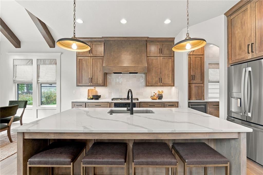 Kitchen island, statement lighting and gas range at 4905 W 71st Street, Prairie Village, KS 66208