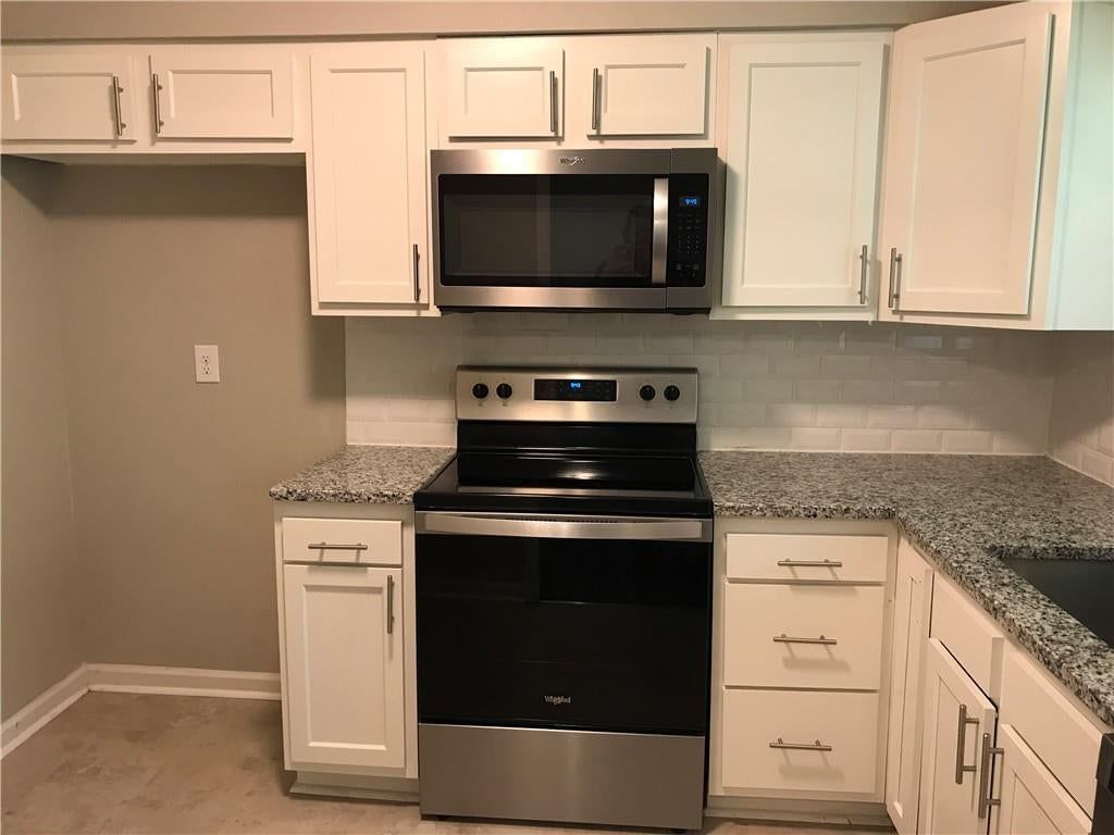 White kitchen, granite counters and stainless steel appliances at 11314 E Thompson Street, Independence, MO 64054