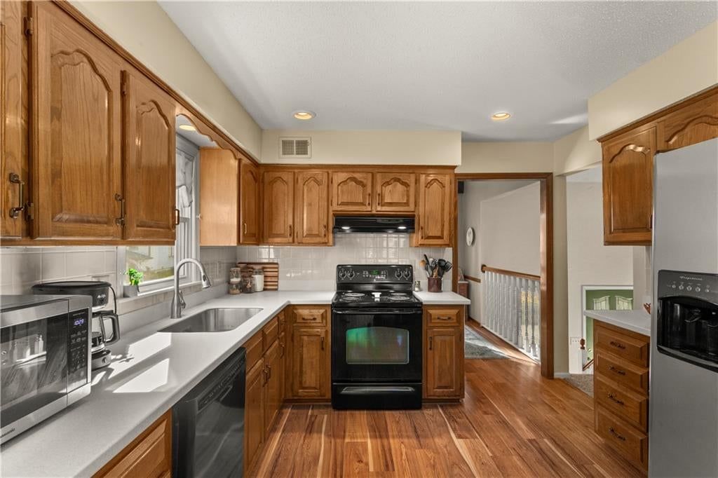 Kitchen island, granite counters and subway tile backsplash at 205 SE Saratoga Drive, Blue Springs, MO 64014