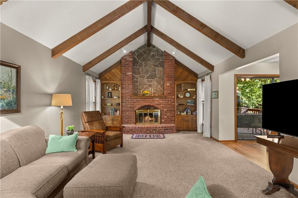 Fireplace, statement lighting and brick fireplace at 205 SE Saratoga Drive, Blue Springs, MO 64014