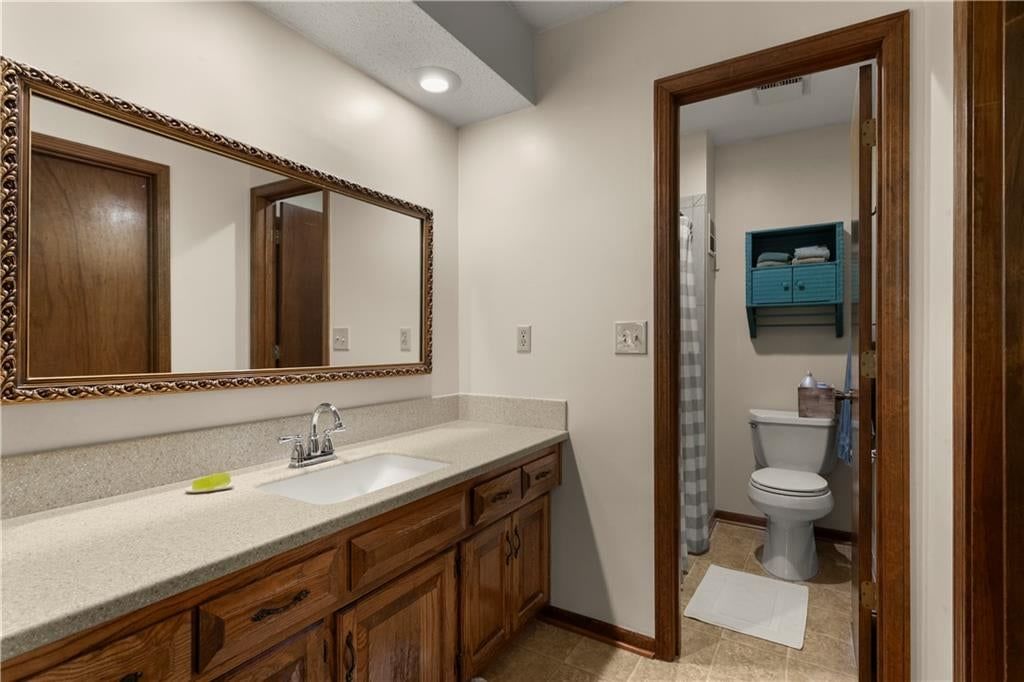 Private toilet room, double vanity and wood vanity at 205 SE Saratoga Drive, Blue Springs, MO 64014