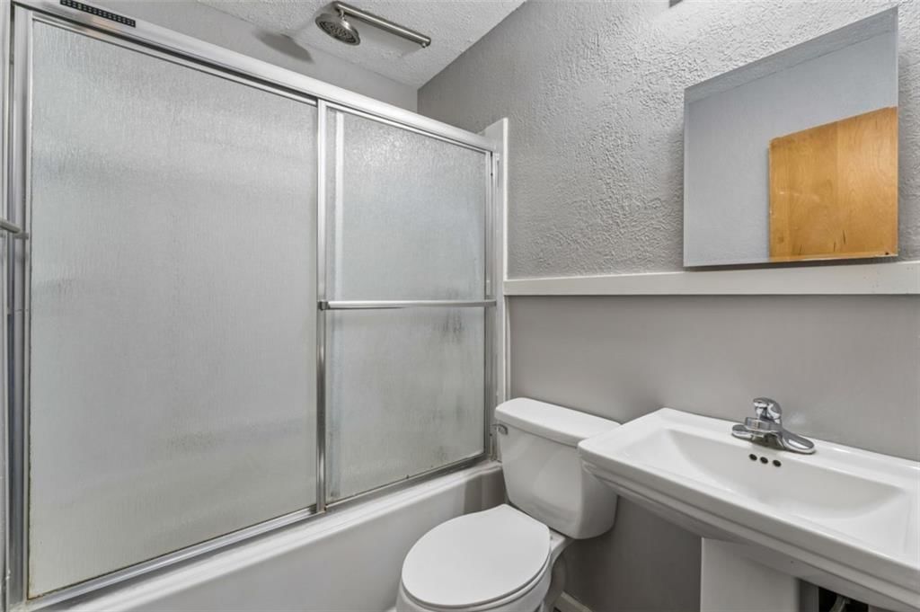 Tiled shower, frameless glass shower and white vanity at 559 E Prairie Street, Olathe, KS 66061