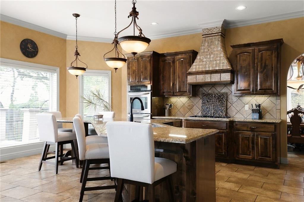 Kitchen island, granite counters and stainless steel appliances at 1205 NW 43rd Terrace, Kansas City, MO 64116