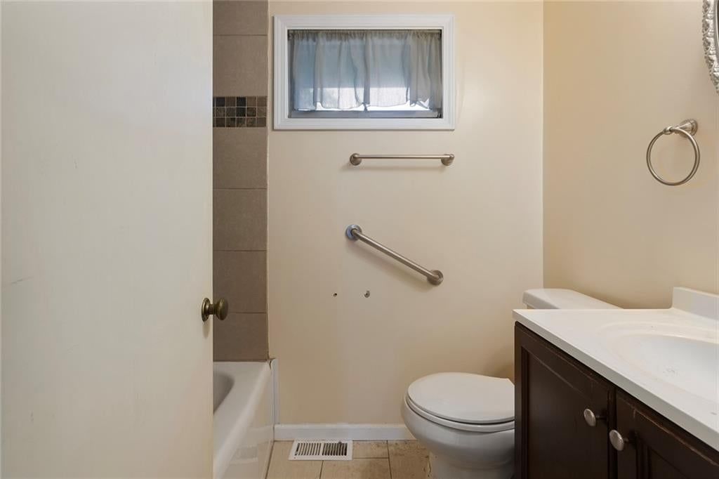 Black vanity, renovated bathrooms and tub and shower combo at 4509 W 75th Street, Prairie Village, KS 66208