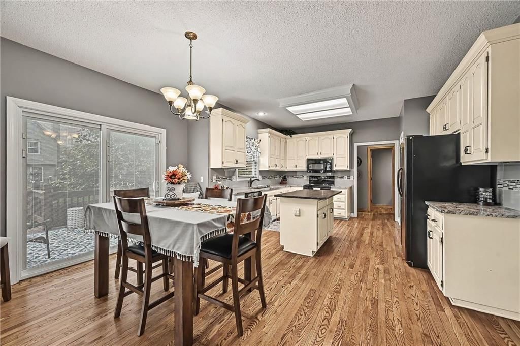 Kitchen island, white kitchen and statement lighting at 21711 W 51st Place, Shawnee, KS 66226