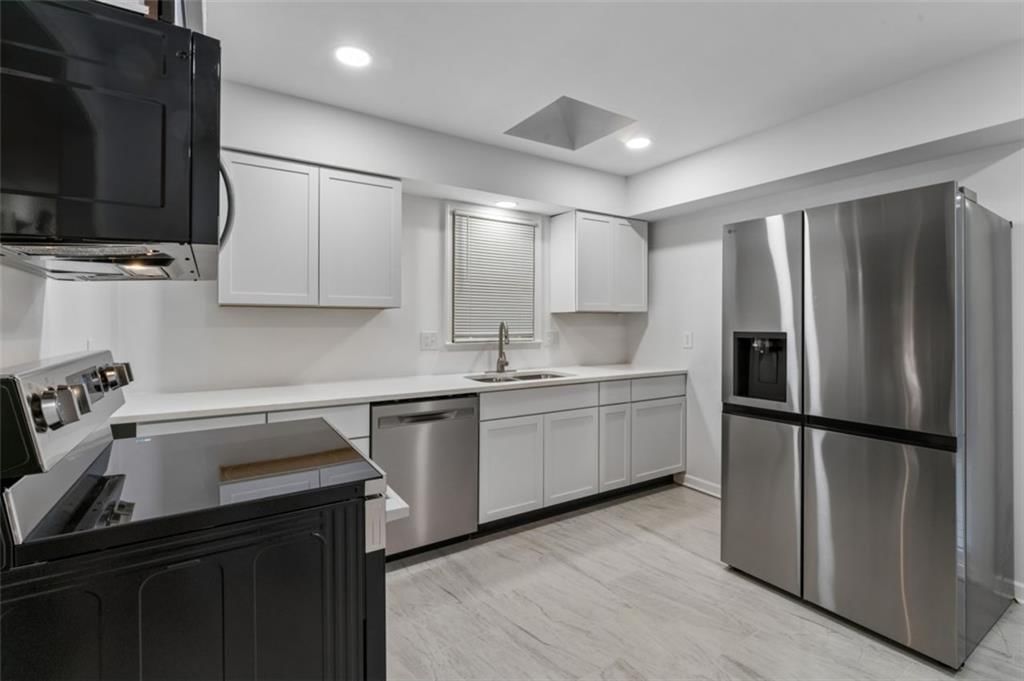 Kitchen open to the living area, white kitchen and quartz counters at 417 N Jefferson Avenue, Liberty, MO 64068