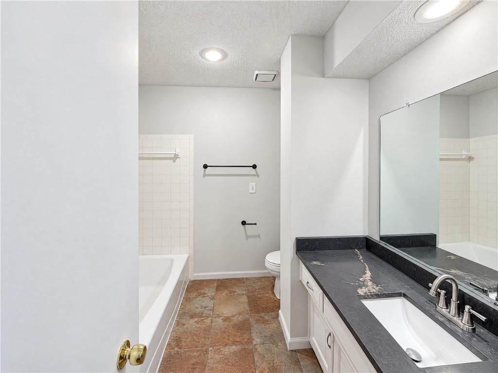 Tile floors, double vanity and tub and shower combo at 14416 Saint Andrews Drive, Grandview, MO 64030
